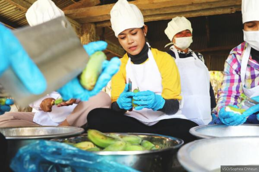 Studenten en trainers pellen bananen om er bananenchips van te maken tijdens de agroprocessing training. 